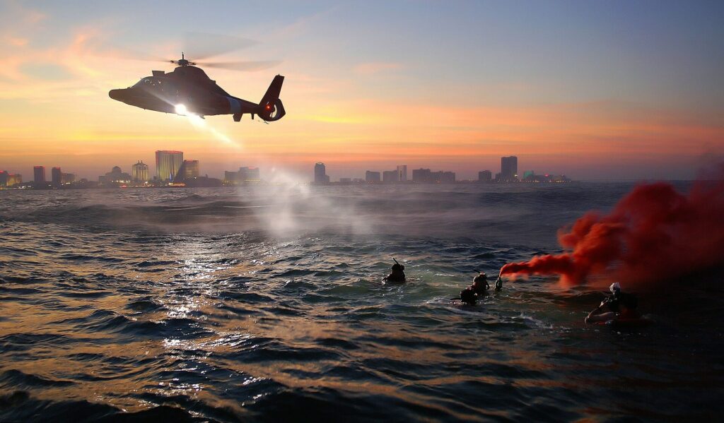Helicopter flies over a group of people in the water while executing a man overboard procedure Helicopter flies over a group of people in the water while executing a man overboard procedure