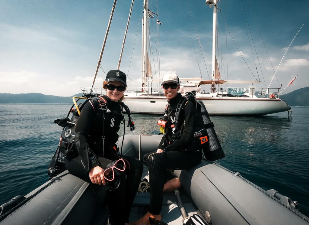 Couple scuba diving from their dinghy in Thailand Couple scuba diving from their dinghy in Thailand