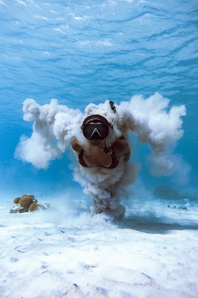 Woman freediving with a diving mask and snorkel along the sand Woman freediving with a diving mask and snorkel along the sand