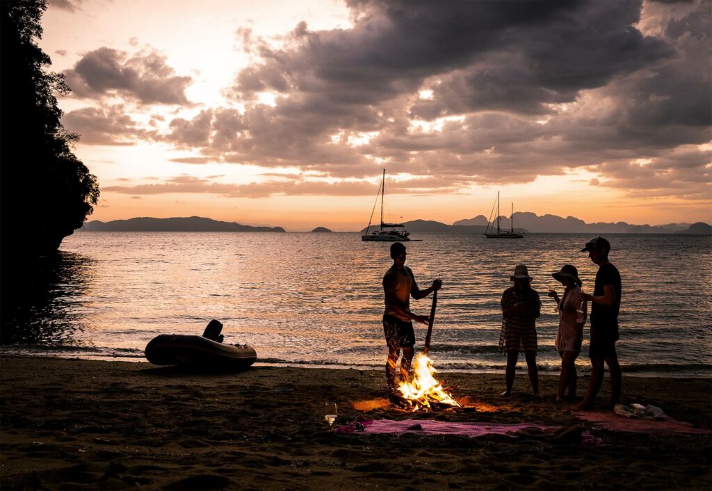 Bonfire with friends on the beach at sunset in Thailand Bonfire with friends on the beach at sunset in Thailand