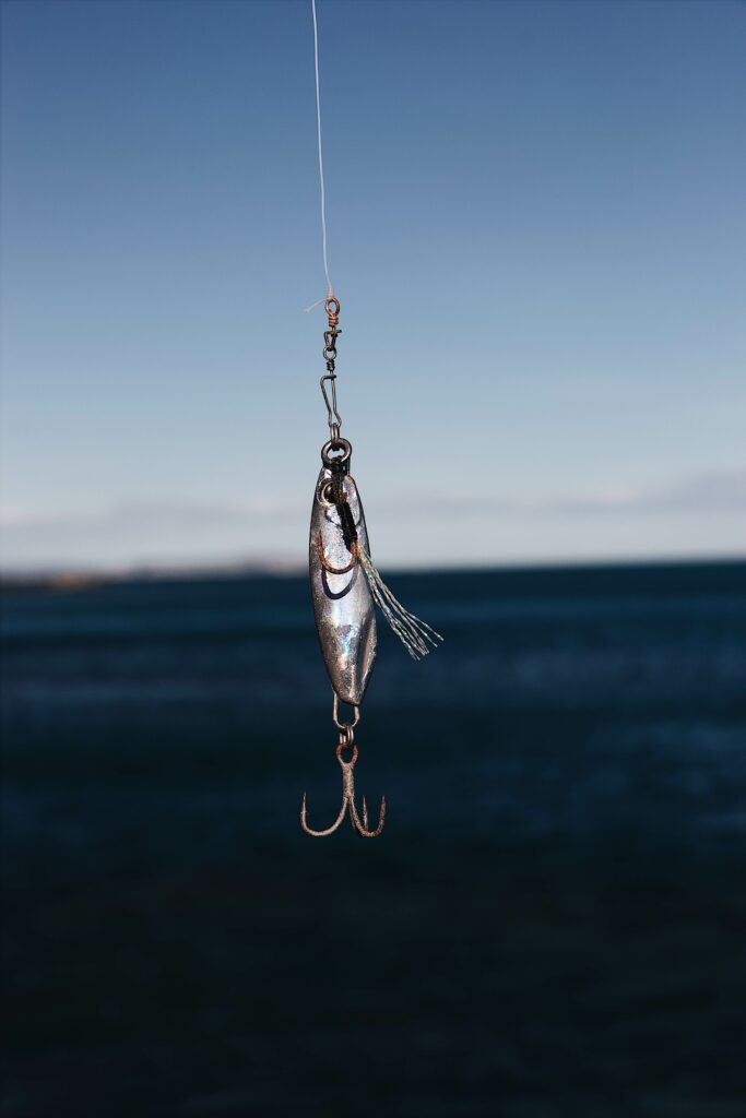 Silver spinning lure hangs on a fishing line Silver spinning lure hangs on a fishing line
