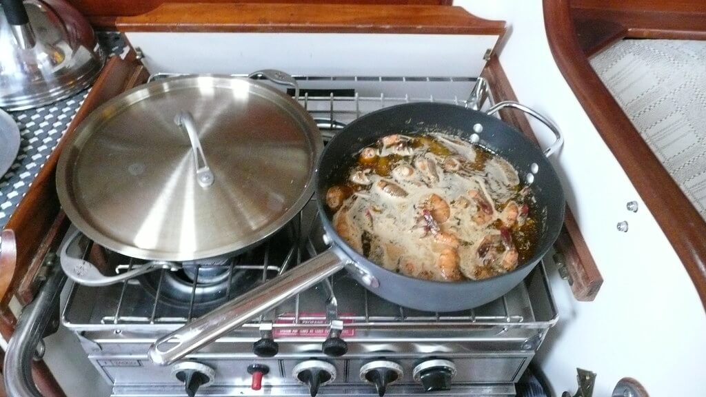 Cooking seafood on a stovetop in a boat galley Cooking seafood on a stovetop in a boat galley
