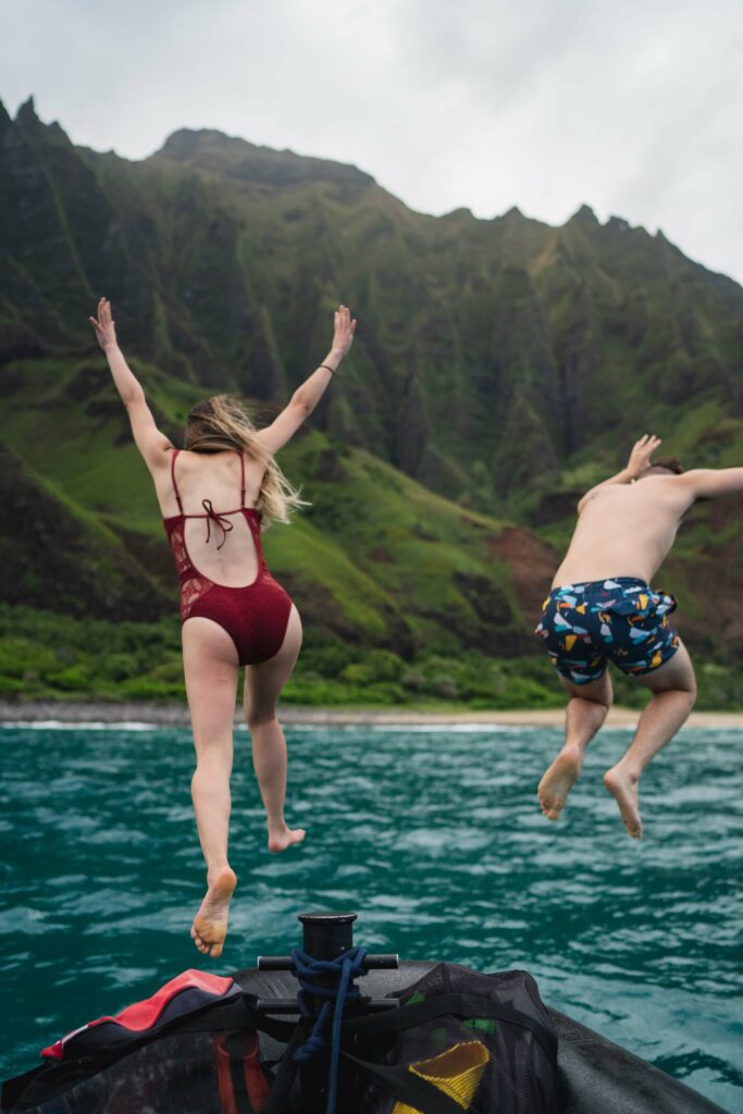 Man and woman jump from a boat into the ocean Man and woman jump from a boat into the ocean