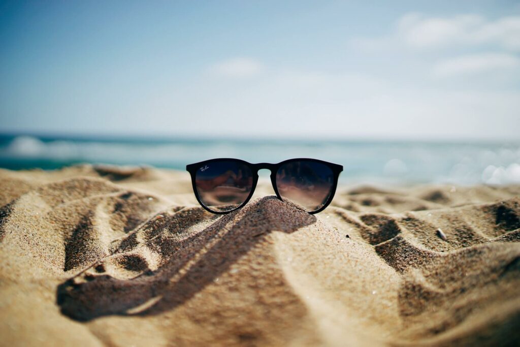 Pair of sunglasses in the sand on a sailing vacation Pair of sunglasses in the sand on a sailing vacation