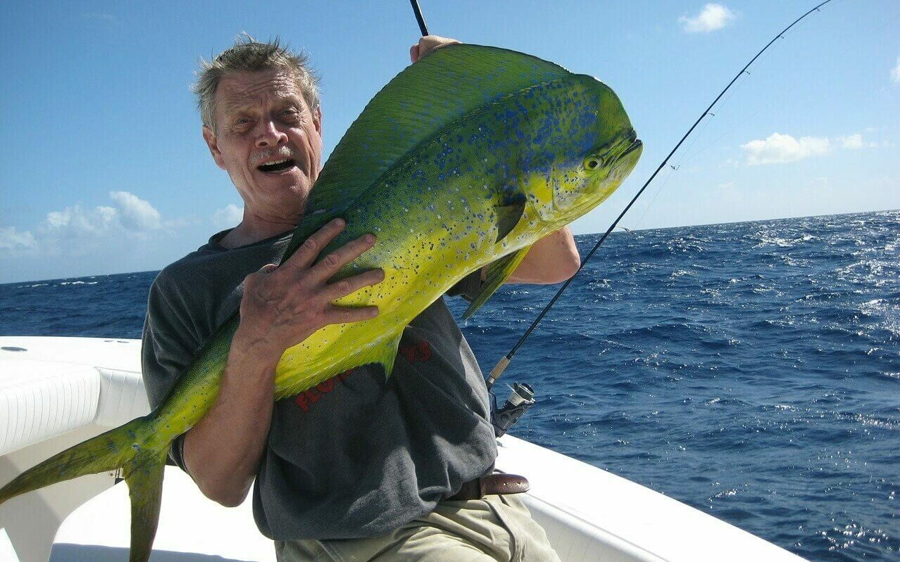 Mahi Mahi Fishing in the Bahamas A man holds a large mahi-mahi that he just caught while fishing from a boat in the Bahamas