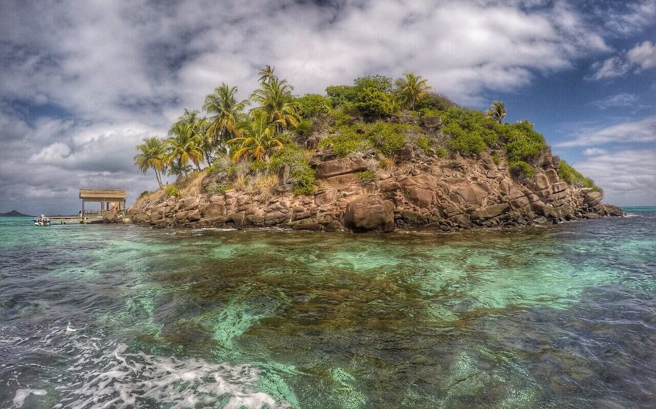 Small Island in the Bahamas A small uninhabited island covered in rocks and palm trees in the Bahamas