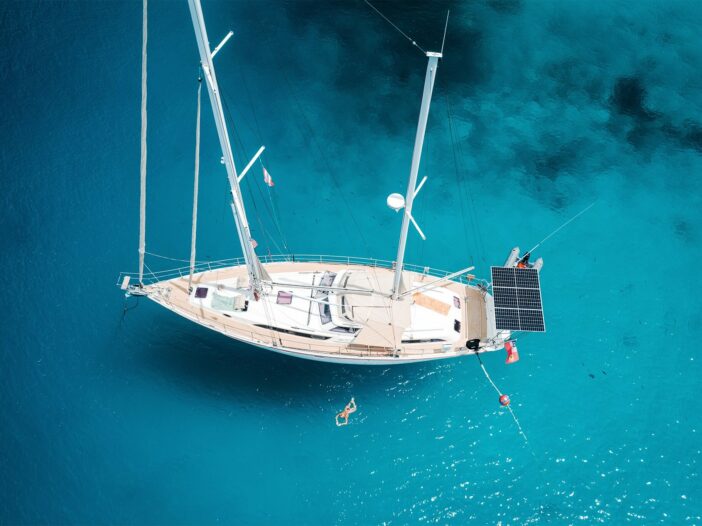 Aerial view of a sailboat with marine solar panels mounted on the stern of the boat