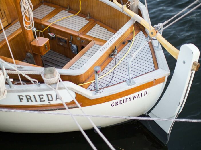 a white sailboat with brown wood trim that recently went through a boat restoration