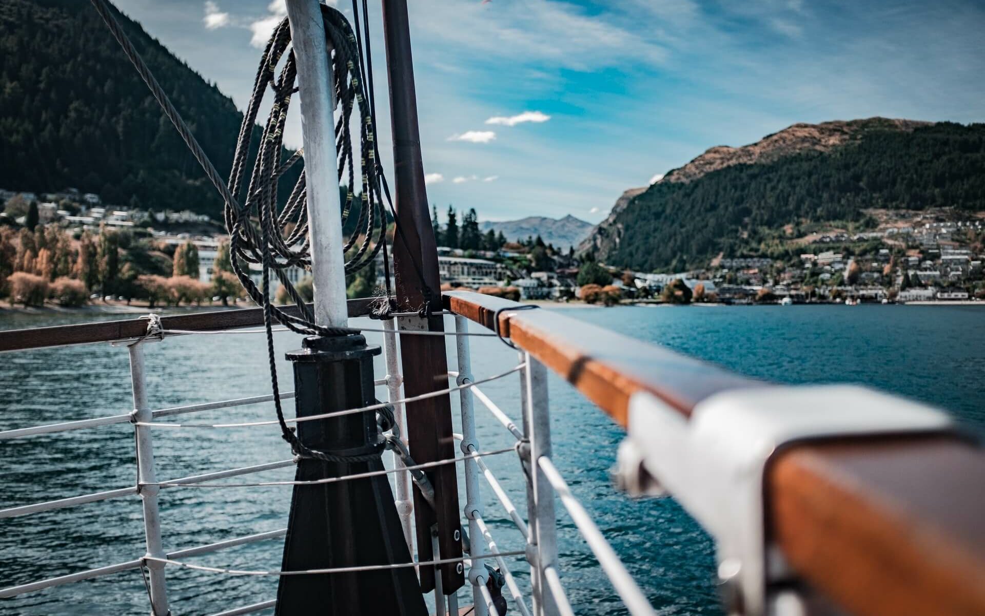 Wooden railings on the bow of a boat looking toward land Wooden railings on the bow of a boat looking toward land